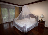 Mosquito-netted bed in Villa Santi Resort and Spa room