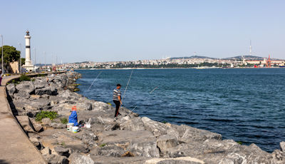 Fisherman on the bank of the Bosphorus near the lighthouse at the entrance to the Golden Horn
